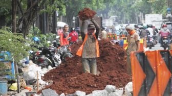 Pekerja meyelesaikan proyek pembuatan lubang resapan air di kawasan Patal Senayan, Jakarta, Senin (26/3).