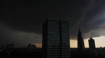 Awan mendung di atas gedung pencakar langit sesaat sebelum hujan deras mengguyur di wilayah Jakarta, Kamis (29/3).