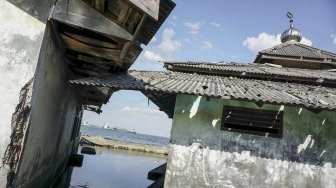 Sebuah bangunan masjid yang sudah tidak difungsikan terendam air laut di kawasan Muara Baru, Penjaringan, Jakarta, Sabtu (31/3). 