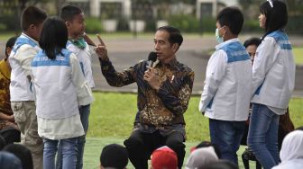 Presiden Joko Widodo (tengah) memberikan kuis untuk anak-anak penderita kanker pendampingan Yayasan Kanker Anak Indonesia saat silaturahmi di halaman belakang Istana Bogor, Jawa Barat, Jumat (6/4).