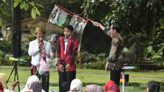 Presiden Joko Widodo (kanan) menghibur anak-anak penderita kanker pendampingan Yayasan Kanker Anak Indonesia dengan pertunjukan gelembung di halaman belakang Istana Bogor, Jawa Barat, Jumat (6/4).