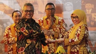 Ratna Dewi Pettalolo memberikan tumpeng kepada Ketua KPU Arif Budiman saat perayaan 1 Dasawarsa Bawaslu di kantor Bawaslu, Jakarta, Senin (9/4). 