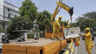 Petugas Unit Peralatan dan Perbekalan (Alkal) Dinas Bina Marga DKI Jakarta memasang beton pembatas jalan di kawasan Jalan Proklamasi Jakarta, Selasa (10/4).