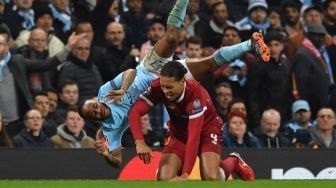 Pemain City Raheem Sterling dijatuhkan bek Liverpool Virgil Van Dijk [AFP]