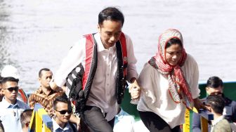 Presiden Joko Widodo (kiri) didampingi Ibu Negara Iriana Joko Widodo (kanan) meninjau proyek pembangunan Jembatan Holtekamp di Jayapura, Papua, Kamis (12/4). 