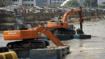 Pengerukan lumpur yang mengendap di bawah sungai Kanal Banjir Barat di kawasan Kota Bambu, Tomang, Jakarta, Kamis (12/4). 