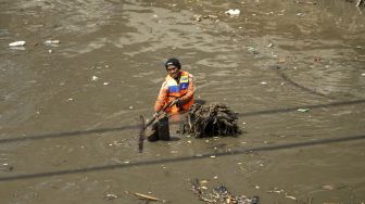 Pengerukan lumpur yang mengendap di bawah sungai Kanal Banjir Barat di kawasan Kota Bambu, Tomang, Jakarta, Kamis (12/4). 