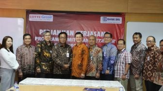 Direktur Hubungan Kelembagaan Bank BRI Sis Apik Wijayanto memberikan plakat penghargaan kepada Presiden Director Lotte Shopping Indonesia  Joseph V. Buntaran usai mendatangani perjanjian kerjasama Layanan dan  Jasa Perbankan, di Head Office Lotte Jakarta, Kamis (12/4).