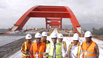 Presiden Joko Widodo (tengan) didampingi Menteri Pekerjaan Umum dan Perumahan Rakyat (PUPR) Basuki Hadimuljono (ketiga kanan) dan sejumlah pejabat daerah setempat memberi keterangan saat meninjau proyek pembangunan Jembatan Holtekamp di Jayapura, Papua, Kamis (12/4).