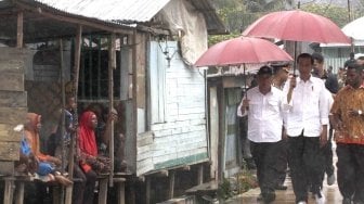 Presiden Joko Widodo (tengah) didampingi Menteri Pekerjaan Umum dan Perumahan Rakyat (PUPR) Basuki Hadimuljono (kiri) mengunjungi pembangunan jalan program padat karya tunai di Kampung Kokoda, Distrik Sorong Manoi, Sorong, Papua Barat Jumat (13/4). 