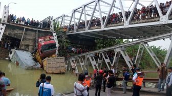 Petugas mengevakuasi truk di lokasi jembatan Widang yang runtuh, Tuban, Jawa Timur, Selasa (17/4).