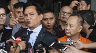 Mantan Kepala Badan Penyehatan Perbankan Nasional (BPPN) Syafruddin Arsyad Temenggung (kanan) diwakili kuasa hukumnya Yusril Ihza Mahendra (kiri) menjawab pertanyaan wartawan seusai menandatangani berkas pelimpahan tahap dua di gedung KPK, Jakarta, Rabu (18/4).