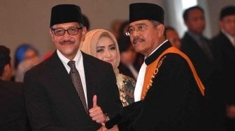 Ketua Mahkamah Agung M Hatta Ali (kanan) memberikan ucapan selamat kepada Deputi Gubernur Bank Indonesia (BI) Dody Budi Waluyo (kiri) yang baru dilantik di Mahkamah Agung, Jakarta, Rabu (18/4).