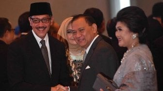 Gubernur Bank Indonesia (BI) Agus Martowardojo (tengah) didampingi istri Nies Berliantin (kanan) memberikan ucapan selamat kepada Deputi Gubernur BI Dody Budi Waluyo seusai pelantikan di Mahkamah Agung, Jakarta, Rabu (18/4).