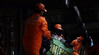 Petugas membersihkan sampah di kolong Jalan Tol Tanjung Priok, Jakarta, Selasa (24/4). 