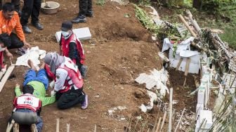 Relawan yang tergabung dalam tim gabungan memberikan pertolongan pertama kepada korban saat simulasi gempa bumi di kawasan Tebing Keraton, Ciburial, Kabupaten Bandung, Jawa Barat, Kamis (26/4). 