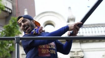 Pemain Barcelona Luis Suarez tersenyum kepada fans saat berparade keliling kota [AFP]