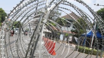 Pihak kepolisian memasang barikade kawat berduri di Jalan Imam Bonjol, Jakarta, Selasa (1/5). 