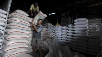 Pekerja mengangkat karung beras di Pasar Induk Beras Cipinang, Jakarta, Rabu (2/5). 