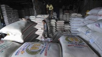 Pekerja mengangkat karung beras di Pasar Induk Beras Cipinang, Jakarta, Rabu (2/5). 