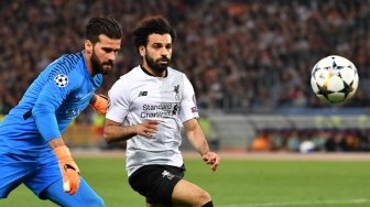 Winger Liverpool Mohamed Salah berebut bola dengan penjaga gawang Roma di semifinal leg kedua Liga Champions yang berlangsung di Stadio Olimpico, Kamis (3/5/2018) [AFP]