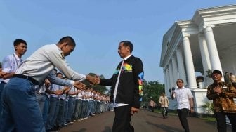 Presiden Joko Widodo yang mengenakan jaket Asian Games menyalami pengurus OSIS SMA berprestasi se-Indonesia ketika menerima kunjungan di Halaman Istana Bogor, Jawa Barat, Kamis (3/5).