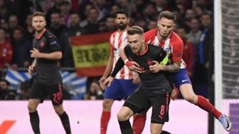 Laju pemain Arsenal Aaron Ramsey dihentikan oleh pemain Atletico Saul Niguez di leg kedua semifinal Liga Europa yang digelar di Estadio Wanda Metropolitano, Jum'at (4/5/2018) [AFP]