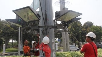 Petugas Dinas Penerangan Jalan Umum melakukan perawatan lampu di Jalan Merdeka Barat, Jakarta, Sabtu (5/5)