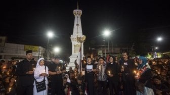 Sejumlah warga mengikuti aksi Solidaritas dan Doa Bersama di Tugu Pal Putih, Yogyakarta, Minggu (13/5). Aksi yang diikuti ratusan warga dari 66 organisasi dan elemen masyarakat di Yogyakakarta itu menjadi bentuk solidaritas dan keprihatinan atas insiden bom bunuh diri di Surabaya pada Sabtu (13/5) pagi. ANTARA