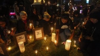 Warga menyalakan lilin dan berdoa bersama untuk korban bom gereja di Surabaya dalam aksi solidaritas di Solo, Jawa Tengah, Minggu (13/5). Dalam aksi tersebut mereka juga mendoakan persatuan dan kesatuan bangsa Indonesia serta hilangnya aksi-aksi terorisme di Indonesia. ANTARA