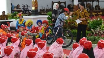 Ibu Negara Iriana Joko Widodo menyalami seorang anak yang mendapatkan sepeda ketika menghadiri acara bergembira bersama ibu negara di Gedung Agung Yogyakarta, Senin (14/5)