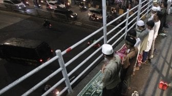 Warga melaksanakan salat Tarawih pertama Ramadan 1439 H di sisi jalan dan jembatan penyeberangan di kawasan Pasar Gembrong, Jatinegara, Jakarta Timur, Rabu (16/5/2018) malam. [Suara.com/Oke Atmaja]