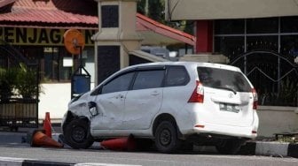 Mobil minibus yang digunakan pelaku teror dalam kondisi rusak di depan pintu masuk Polda Riau, di Pekanbaru, Riau, Jumat (16/5).