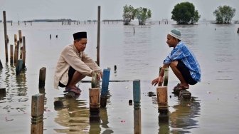 Warga berziarah di makam kerabatnya di tempat pemakaman umum (TPU) yang terdampak abrasi di Tambaklorok, Semarang, Jawa Tengah, Rabu (16/5). 