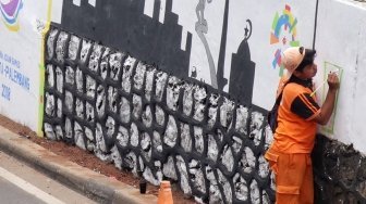 Petugas PPSU membuat mural bertema Asian Games di kawasan Kebagusan, Jakarta, Kamis (17/5).