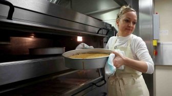 Pemilik Violet Bakery, Claire Ptak menyelesaikan kue untuk pernikahan Pangeran Harry dan Meghan Markle di dapur Istana Buckingham, London, Kamis (17/5).