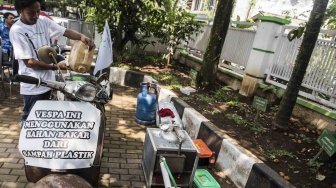 Aktivis Gerakan Tarik Plastik (Get Plastic) menuangkan bahan bakar minyak jenis premium ke dalam tangki motor Vespa saat pelatihan dan sosialisasi pengolahan sampah plastik di Bandung, Jawa Barat, Senin (21/5). 