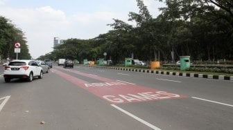 Kendaraan melintas di samping jalur khusus kontingen Asian Games 2018 di Jalan Benyamin Sueb, Kemayoran, Jakarta, Selasa (22/5).