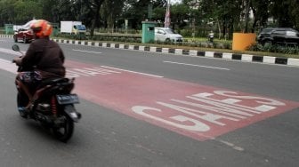 Kendaraan melintas di samping jalur khusus kontingen Asian Games 2018 di Jalan Benyamin Sueb, Kemayoran, Jakarta, Selasa (22/5).