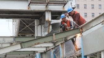 Sejumlah pekerja membongkar halte TransJakarta BNN di kawasan Cawang, Jakarta, Rabu (23/5).