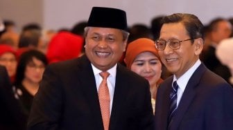 Mantan Wakil Presiden yang juga mantan Gubernur Bank Indonesia Budiono (kanan) memberikan selamat kepada Gubernur Bank Indonesia Perry Warjiyo (kanan) usai pelantikannya di Mahkamah Agung, Jakarta, Kamis (24/5).