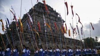 Umat Budha melakukan pradaksina atau mengelilingi candi membawa Api Dharma dengan obor yang diambil dari api abadi Mrapen Kabupaten Grobogan saat prosesi penyemayaman Api Dharma Waisak 2018 di Candi Mendut, Magelang, Jawa Tengah, Minggu (27/5). 