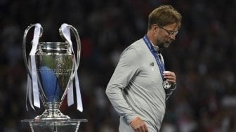 Manajer Liverpool Jurgen Klopp berjalan melewati trofi Liga Champions setelah skuatnya kalah dari Real Madrid 1-3. Paul ELLIS / AFP