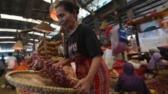 Seorang pekerja memilah bawang merah yang dijual di Pasar Induk Kramat Jati, Jakarta, Selasa (29/5). 