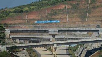 Kendaraan melintas di dekat proyek pembangunan jalan tol Cileunyi-Sumedang-Dawuan (Cisumdawu) di Rancakalong, Kabupaten Sumedang, Jawa Barat, Selasa, (29/5). 