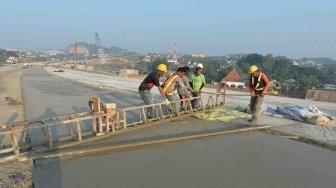 Pekerja mengerjakan pengecoran lapisan beton proyek Jalan Tol Batang-Semarang di kawasan Simpang Susun Krapyak, Semarang, Jawa Tengah, Jumat (1/6). 