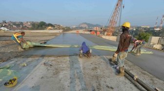 Pekerja mengerjakan pengecoran lapisan beton proyek Jalan Tol Batang-Semarang di kawasan Simpang Susun Krapyak, Semarang, Jawa Tengah, Jumat (1/6). 