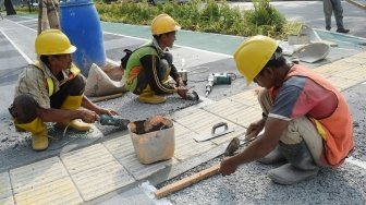 Pekerja menyelesaikan proyek perbaikan pedestrian di kawasan Gelora Bung Karno (GBK), Senayan, Jakarta, Selasa (5/6). 