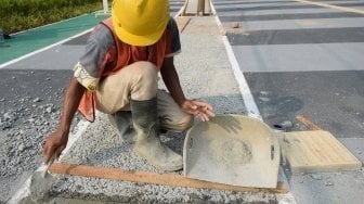 Pekerja menyelesaikan proyek perbaikan pedestrian di kawasan Gelora Bung Karno (GBK), Senayan, Jakarta, Selasa (5/6). 