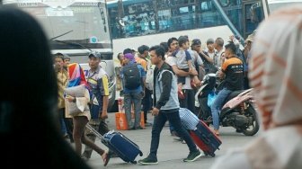 Sejumlah pemudik terlihat bergegas sementara sebagian lainnya menunggu bus di Terminal Kampung Rambutan, Jakarta, Sabtu (9/6/2018). [Suara.com/Oke Atmaja]